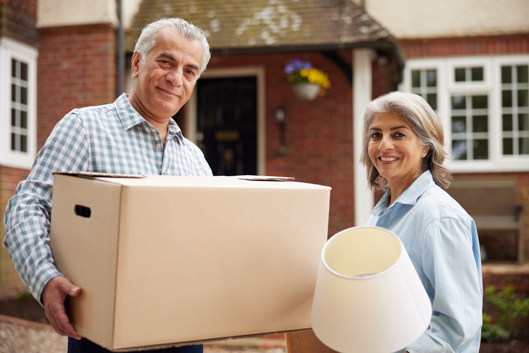 Aging adults holding boxes, downsizing to senior living community Charleston, WV