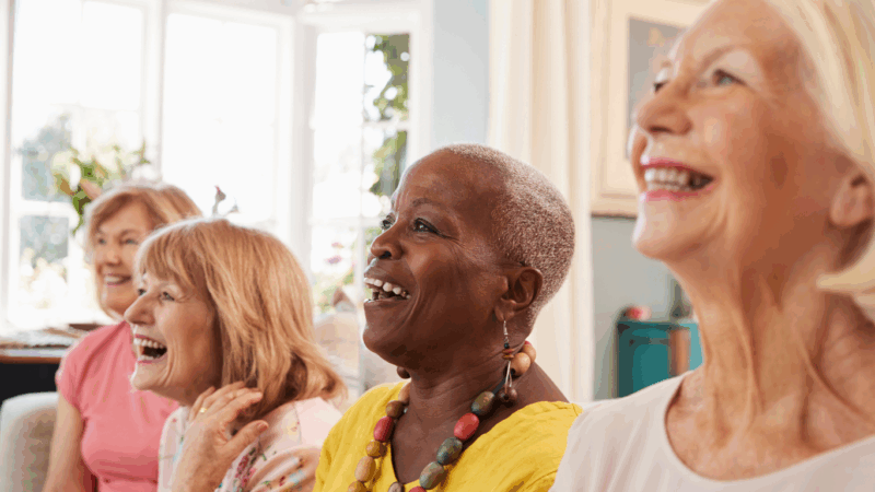 Four women laughing and smiling together