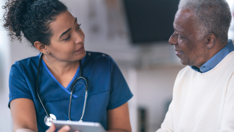 Woman healthcare worker talking to senior man