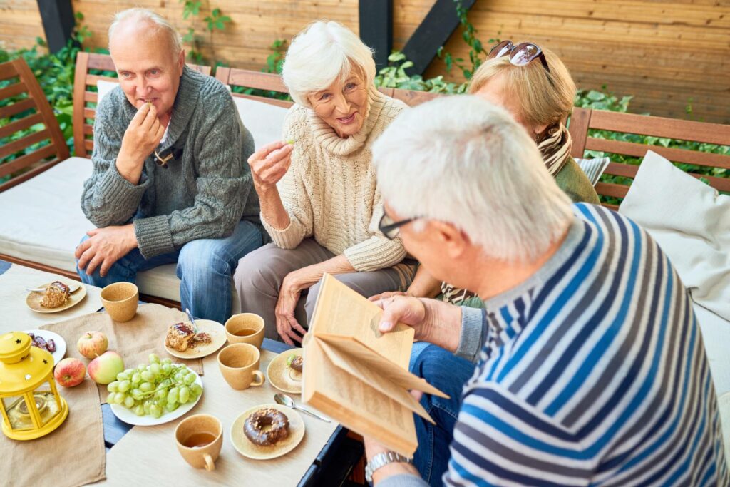 Group of seniors spending time outside while eating appetizers